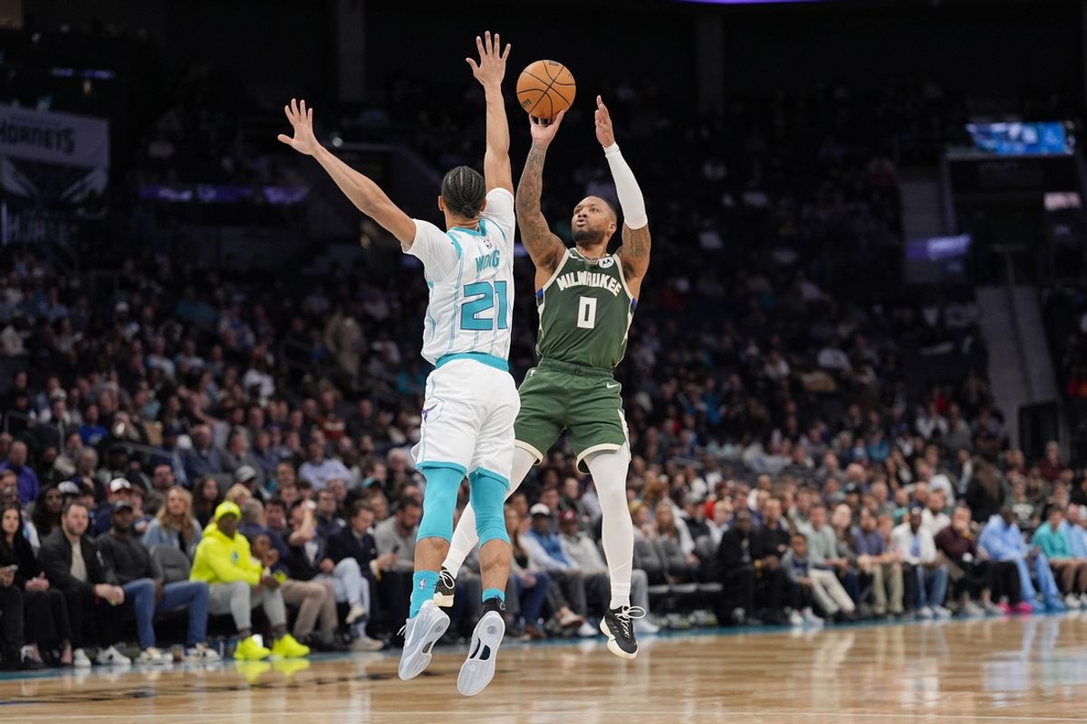 Feb 5, 2025; Charlotte, North Carolina, USA; Milwaukee Bucks guard Damian Lillard (0) shoots the jumper over Charlotte Hornets guard KJ Simpson (25) during the second quarter at Spectrum Center. Mandatory Credit: Jim Dedmon-Imagn Images