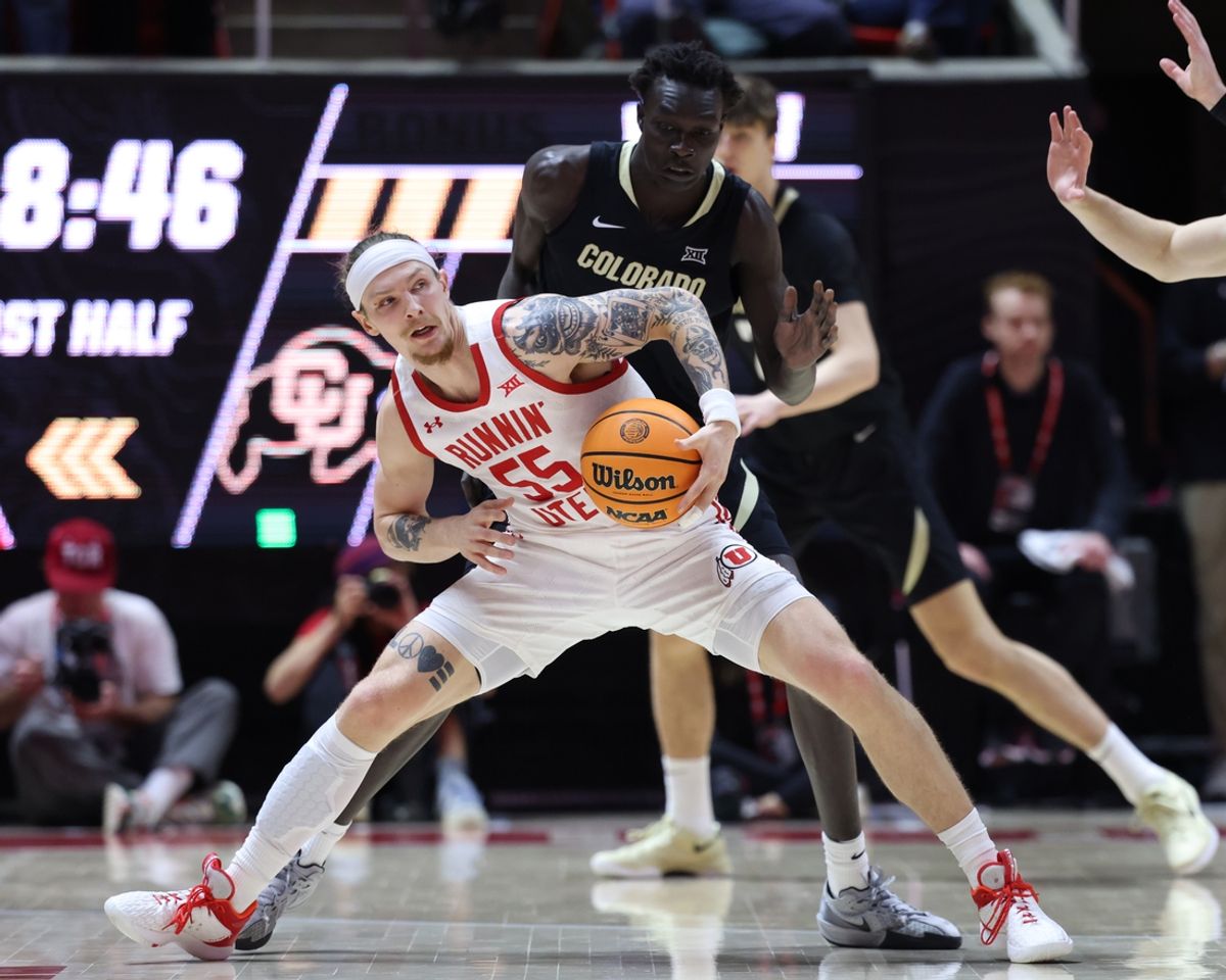 Feb 5, 2025; Salt Lake City, Utah, USA; Utah Utes guard Gabe Madsen (55) moves the ball against Colorado Buffaloes forward Bangot Dak (rear) during the first half at Jon M. Huntsman Center. Mandatory Credit: Rob Gray-Imagn Images