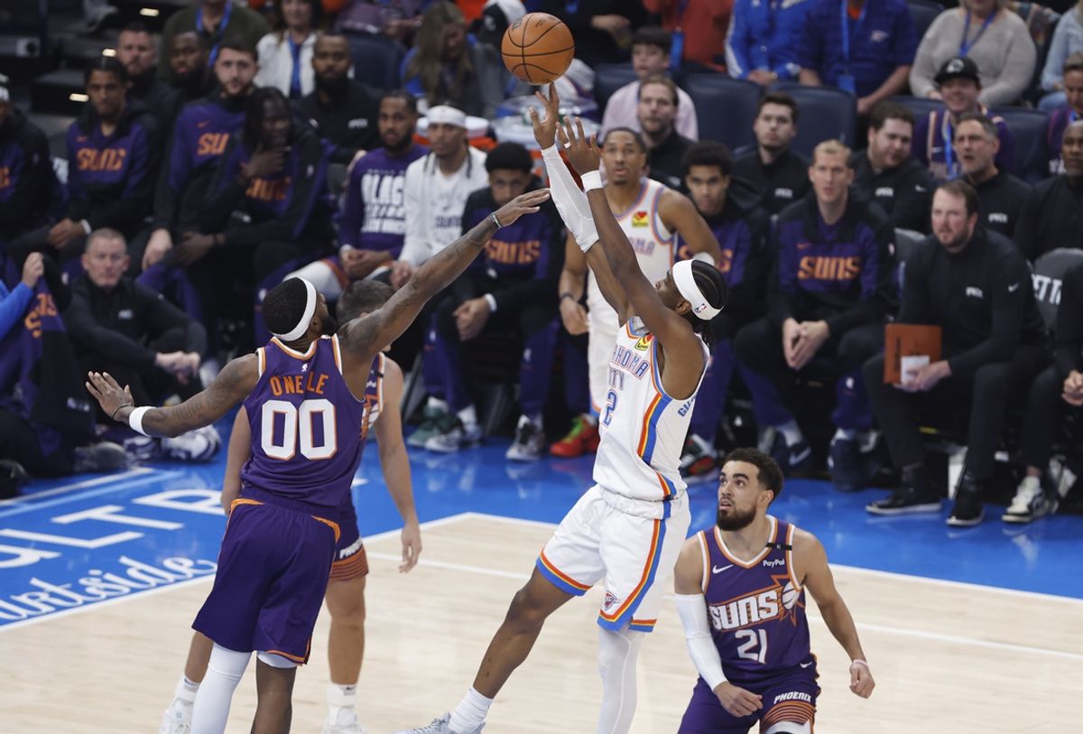 Feb 5, 2025; Oklahoma City, Oklahoma, USA; Oklahoma City Thunder guard Shai Gilgeous-Alexander (2) shoots as Phoenix Suns forward Royce O'Neale (00) defends during the first quarter of a game at Paycom Center. Mandatory Credit: Alonzo Adams-Imagn Images