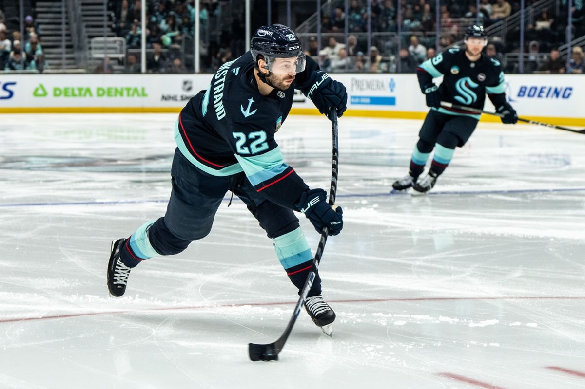 Feb 2, 2025; Seattle, Washington, USA;  Seattle Kraken forward Oliver Bjorkstrand (22) takes a shot against the Calgary Flames at Climate Pledge Arena. Mandatory Credit: Stephen Brashear-Imagn Images