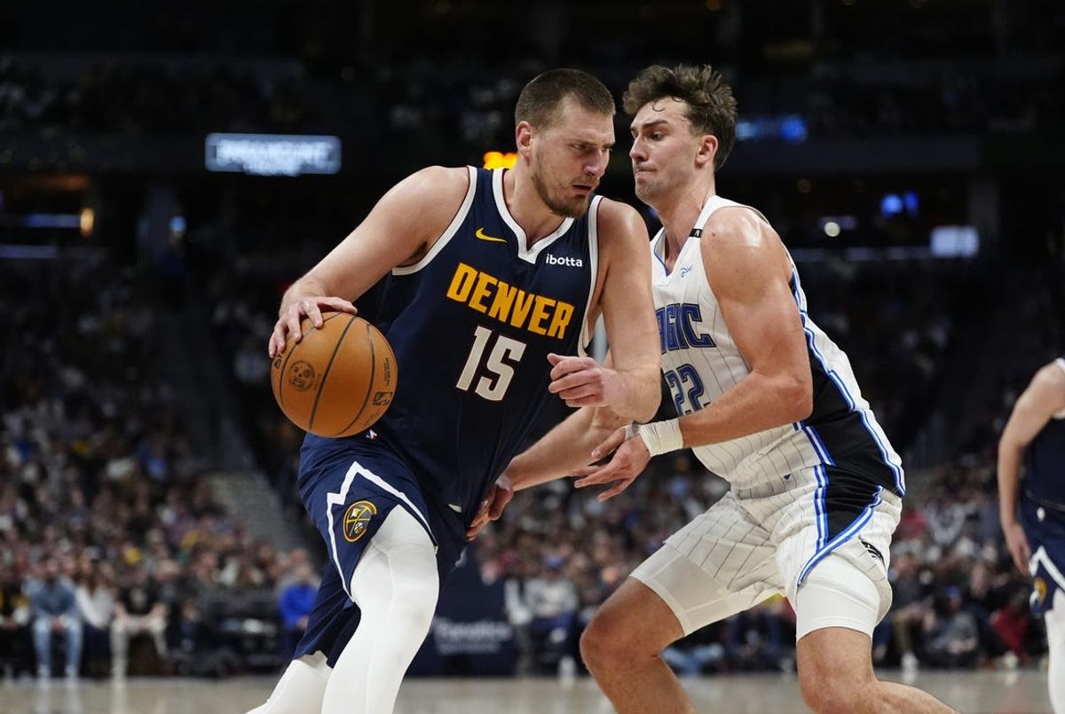 Feb 6, 2025; Denver, Colorado, USA; Denver Nuggets center Nikola Jokic (15) drives against Orlando Magic forward Franz Wagner (22) in the second quarter at Ball Arena. Mandatory Credit: Ron Chenoy-Imagn Images