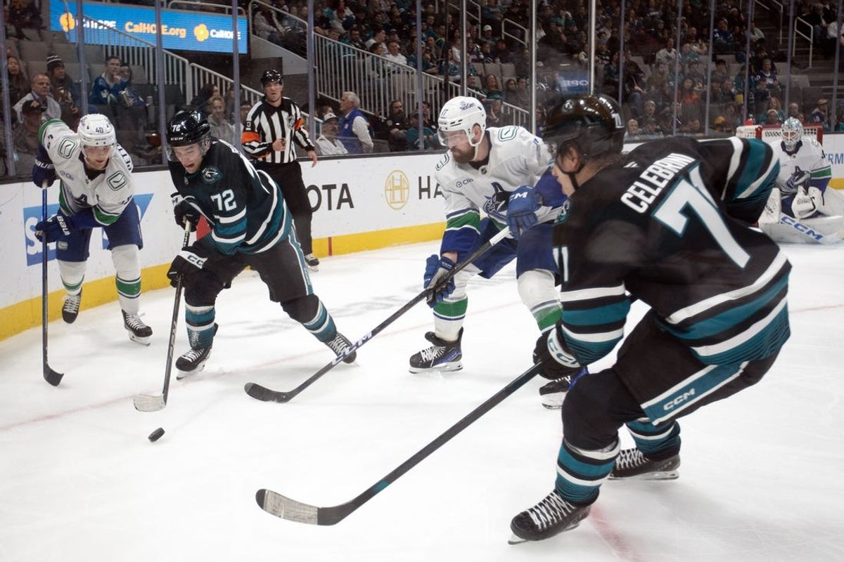 Feb 6, 2025; San Jose, California, USA; San Jose Sharks left winger William Eklund (72) tries to control the puck between Vancouver Canucks center Elias Pettersson (40) and defenseman Filip Hronek (17) during the second period at SAP Center at San Jose. Mandatory Credit: D. Ross Cameron-Imagn Images