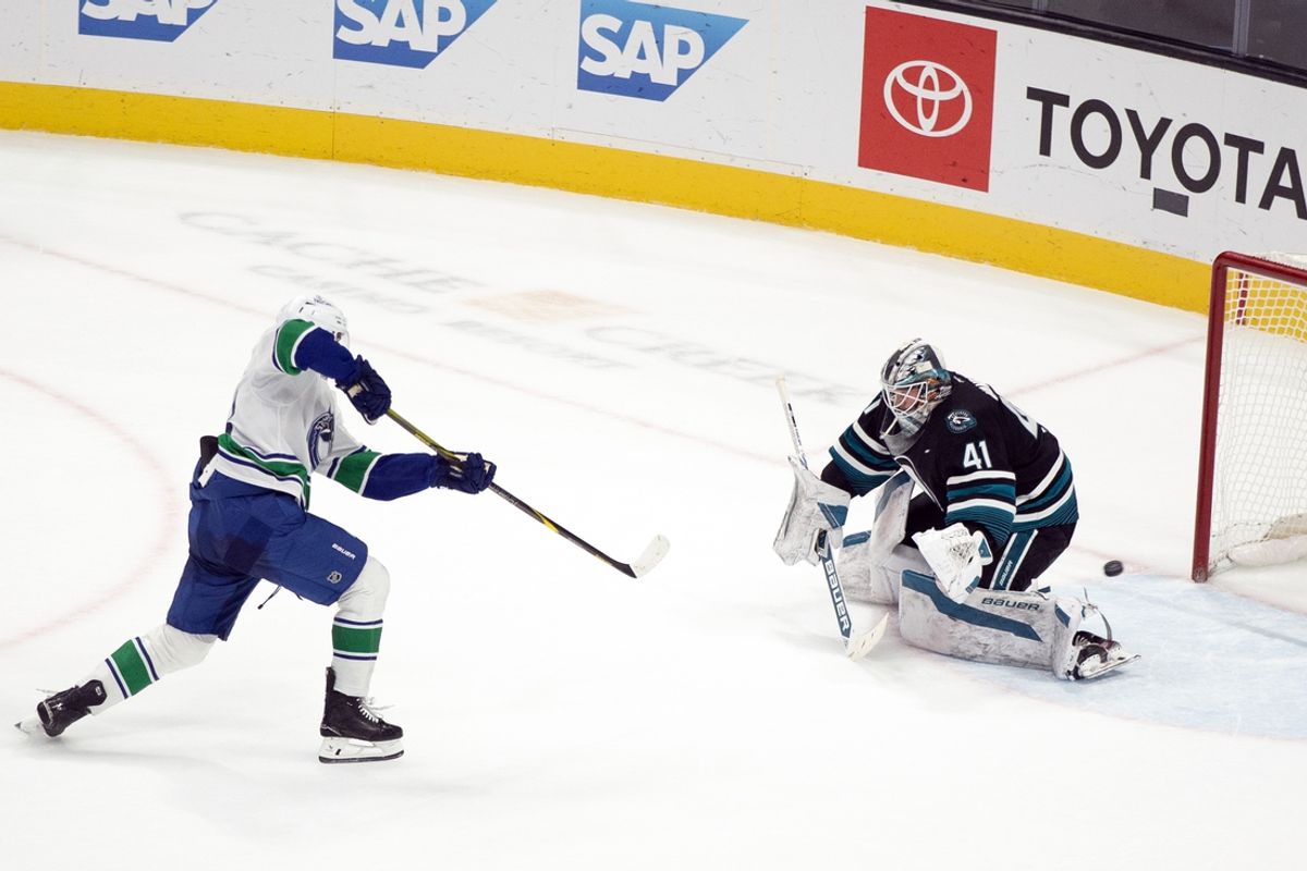 Feb 6, 2025; San Jose, California, USA; Vancouver Canucks left winger Drew O'Connor (18) scores past San Jose Sharks goaltender Vitek Vanecek (41) on a penalty shot during overtime at SAP Center at San Jose. The Canucks won 2-1. Mandatory Credit: D. Ross Cameron-Imagn Images