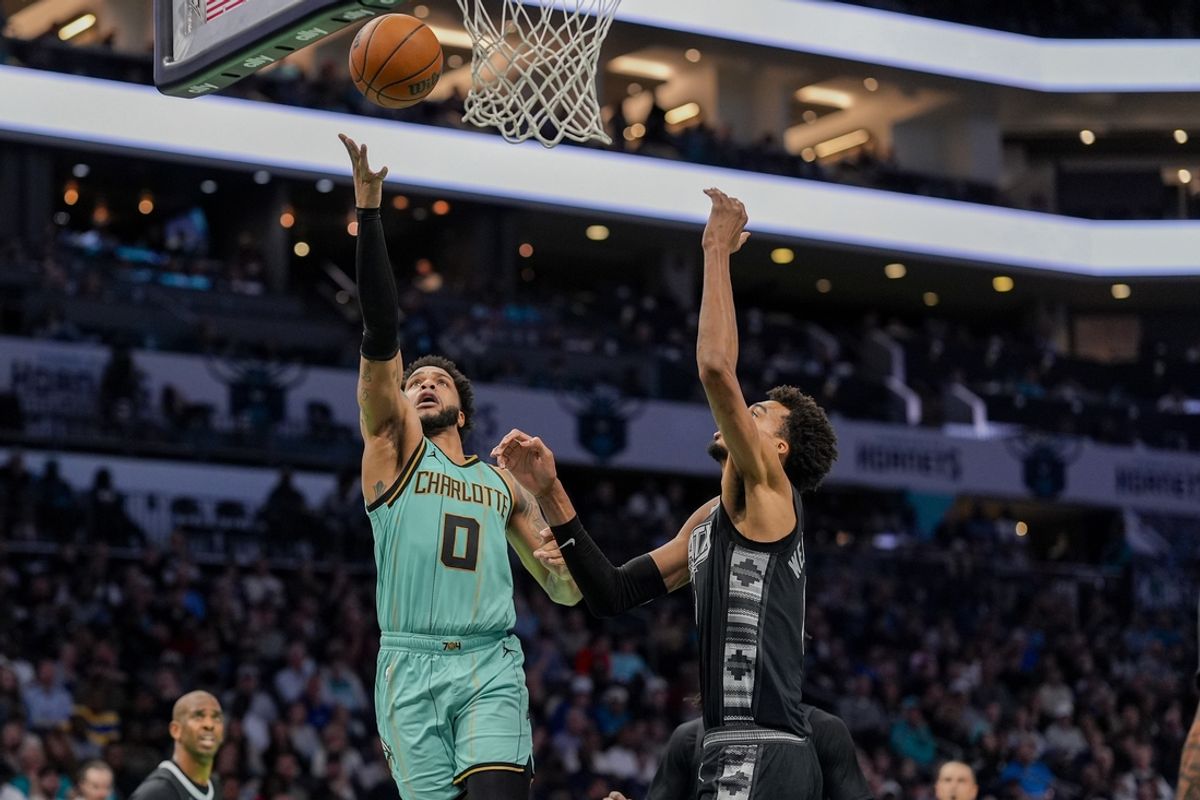 Feb 7, 2025; Charlotte, North Carolina, USA; Charlotte Hornets forward Miles Bridges (0) goes to the basket against San Antonio Spurs center Victor Wembanyama (1) during the second quarter at Spectrum Center. Mandatory Credit: Jim Dedmon-Imagn Images