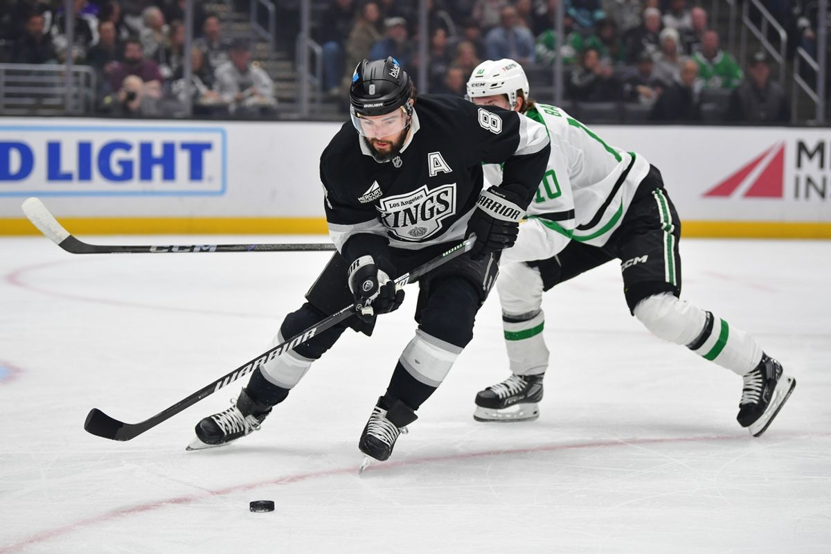 Feb 7, 2025; Los Angeles, California, USA; Los Angeles Kings defenseman Drew Doughty (8) moves the puck against Dallas Stars center Oskar Back (10) durng the first period at Crypto.com Arena. Mandatory Credit: Gary A. Vasquez-Imagn Images