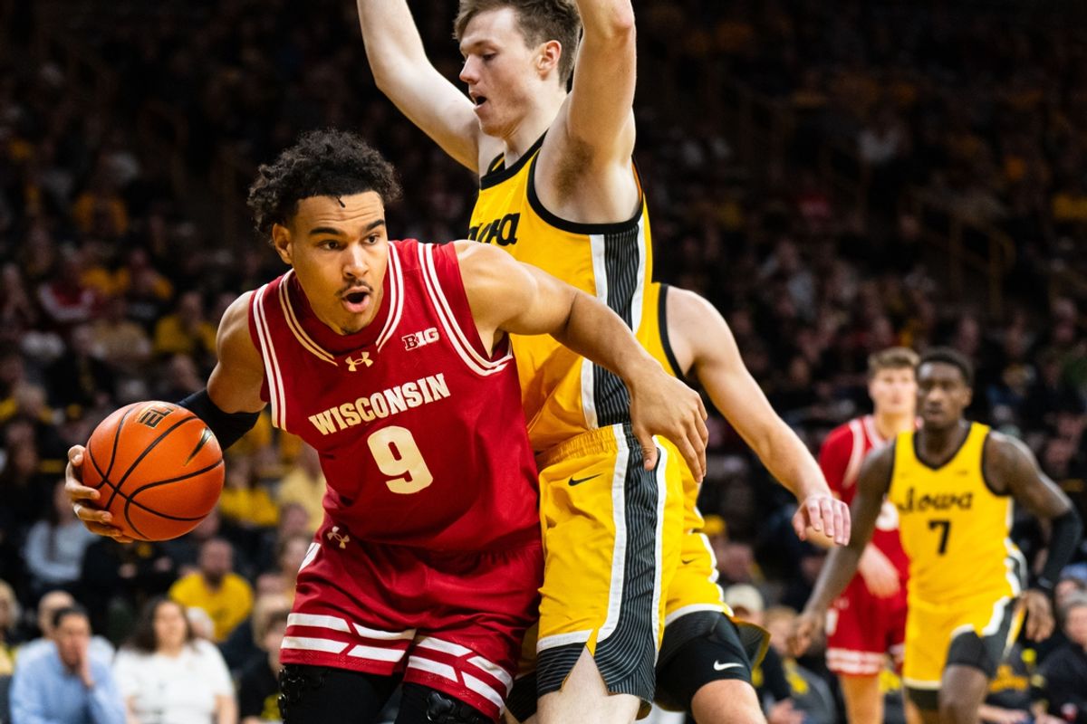 Feb 8, 2025; Iowa City, Iowa, USA; Wisconsin Badgers guard John Tonje (9) drives against Iowa Hawkeyes forward Riley Mulvey (44) during the first half at Carver-Hawkeye Arena. Mandatory Credit: Dylan Widger-Imagn Images
