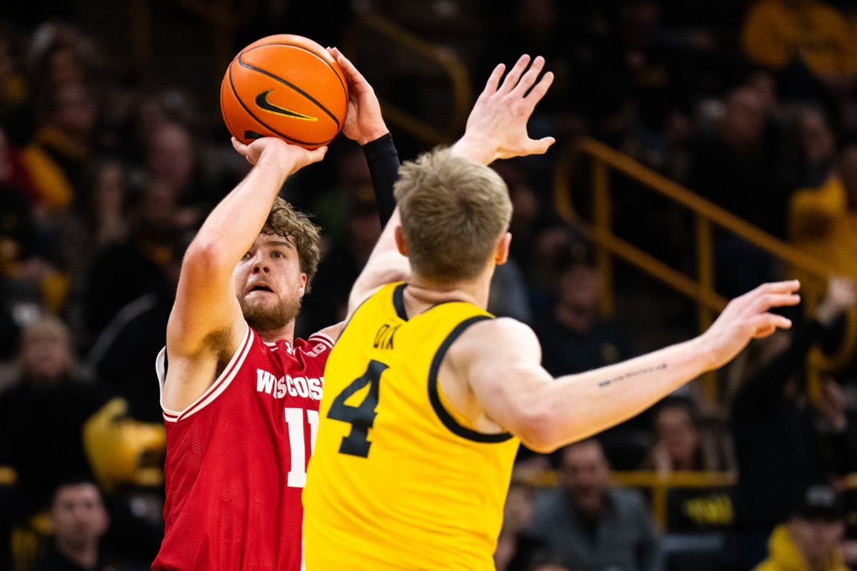 Feb 8, 2025; Iowa City, Iowa, USA; Wisconsin Badgers guard Max Klesmit (11) shoots a three point basket against Iowa Hawkeyes guard Josh Dix (4) at Carver-Hawkeye Arena. Mandatory Credit: Dylan Widger-Imagn Images