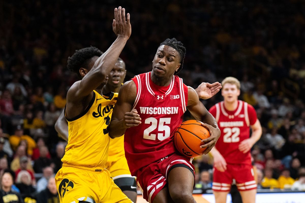 Feb 8, 2025; Iowa City, Iowa, USA; Wisconsin Badgers guard John Blackwell (25) drives against Iowa Hawkeyes guard Drew Thelwell (3) during the first half at Carver-Hawkeye Arena. Mandatory Credit: Dylan Widger-Imagn Images