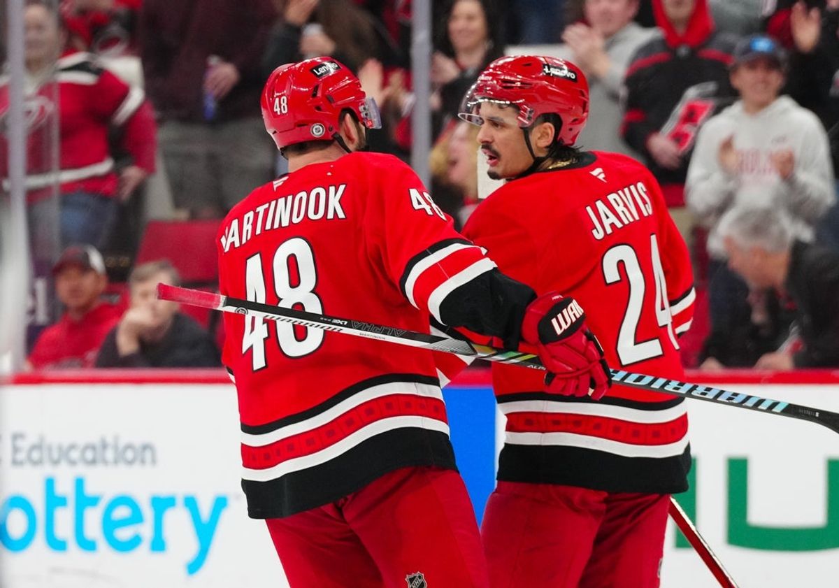 Feb 8, 2025; Raleigh, North Carolina, USA;  Carolina Hurricanes left wing Jordan Martinook (48) celebrates his empty net goal with center Seth Jarvis (24) against the Utah Hockey Club during the third period at Lenovo Center. Mandatory Credit: James Guillory-Imagn Images