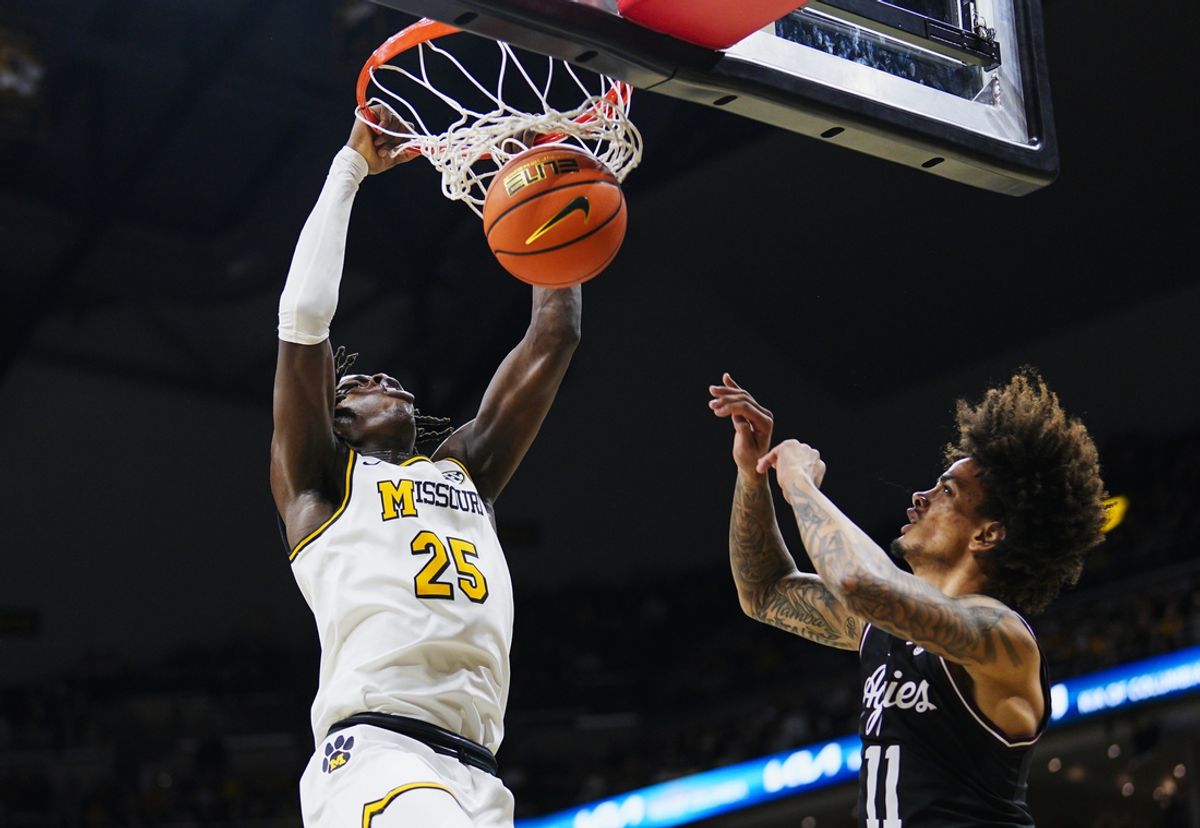 Feb 8, 2025; Columbia, Missouri, USA; Missouri Tigers guard Mark Mitchell (25) dunks the ball against Texas A&M Aggies forward Andersson Garcia (11) during the first half at Mizzou Arena. Mandatory Credit: Jay Biggerstaff-Imagn Images