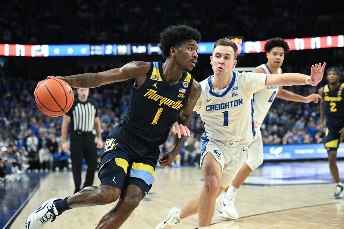 Feb 8, 2025; Omaha, Nebraska, USA; Marquette Golden Eagles guard Kam Jones (1) drives against Creighton Bluejays guard Steven Ashworth (1) in the second half at CHI Health Center Omaha. Mandatory Credit: Steven Branscombe-Imagn Images