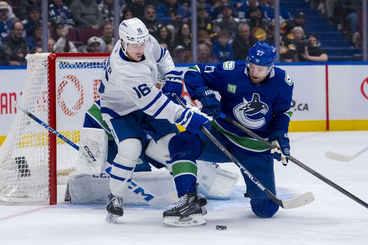 Feb 8, 2025; Vancouver, British Columbia, CAN; Toronto Maple Leafs forward Mitch Marner (16) battles with Vancouver Canucks defenseman Derek Forbort (27) in the first period at Rogers Arena. Mandatory Credit: Bob Frid-Imagn Images