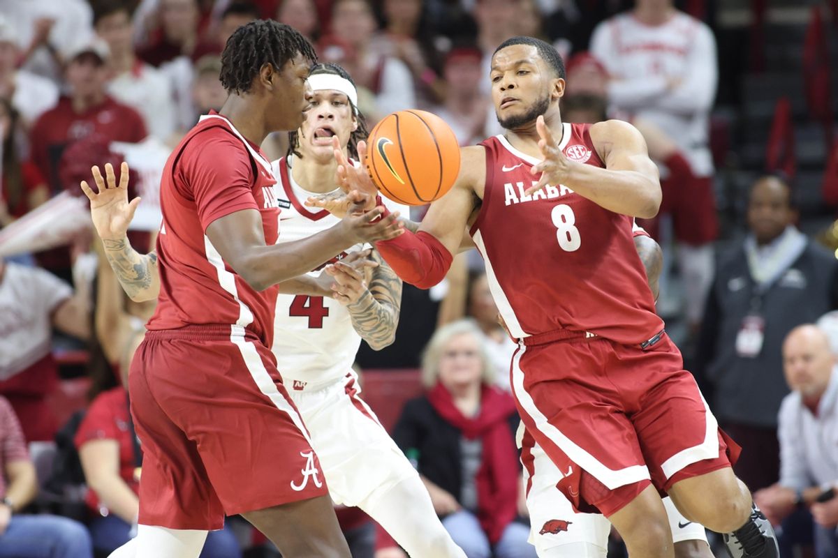 Feb 8, 2025; Fayetteville, Arkansas, USA; Arkansas Razorbacks forward Trevon Brazile (4) attempts to break up a pass to Alabama Crimson Tide guard Chris Youngblood (8) during the first half at Bud Walton Arena. Mandatory Credit: Nelson Chenault-Imagn Images