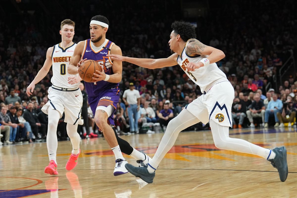 Feb 8, 2025; Phoenix, Arizona, USA; Phoenix Suns guard Devin Booker (1) drives against Denver Nuggets guard Julian Strawther (3) during the first half at Footprint Center. Mandatory Credit: Joe Camporeale-Imagn Images