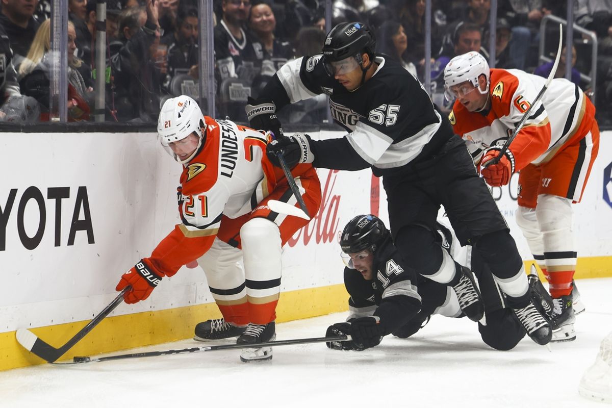 Feb 8, 2025; Los Angeles, California, USA; Anaheim Ducks center Isac Lundestrom (21), Los Angeles Kings right wing Quinton Byfield (55), and right wing Alex Laferriere (14) battle for the puck during the second period of a hockey game at Crypto.com Arena. Mandatory Credit: Jessica Alcheh-Imagn Images