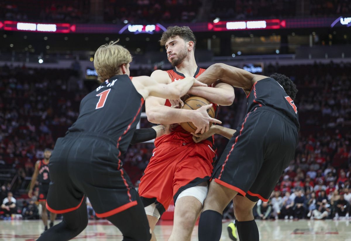 Feb 9, 2025; Houston, Texas, USA; Houston Rockets center Alperen Sengun (28) attempts to control a loose ball as Toronto Raptors guard Gradey Dick (1) and forward Scottie Barnes (4) defend during the first quarter at Toyota Center. Mandatory Credit: Troy Taormina-Imagn Images