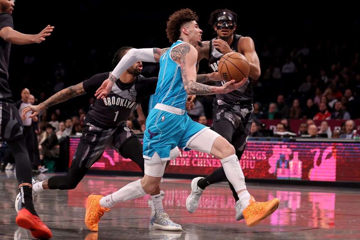 Feb 10, 2025; Brooklyn, New York, USA; Charlotte Hornets guard LaMelo Ball (1) drives to the basket against Brooklyn Nets guard D'Angelo Russell (1) and center Nic Claxton (33) during the first quarter at Barclays Center. Mandatory Credit: Brad Penner-Imagn Images
