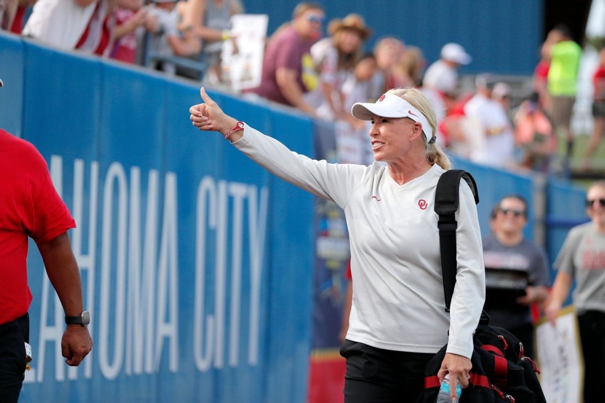 Oklahoma coach Patty Gasso gestures to fans as she walks on the field before Game 2 of the NCAA softball Women's College World Series Championship Series game between the Oklahoma Sooners and Texas Longhorns at Devon Park in Oklahoma City, Thursday, June 6, 2024.