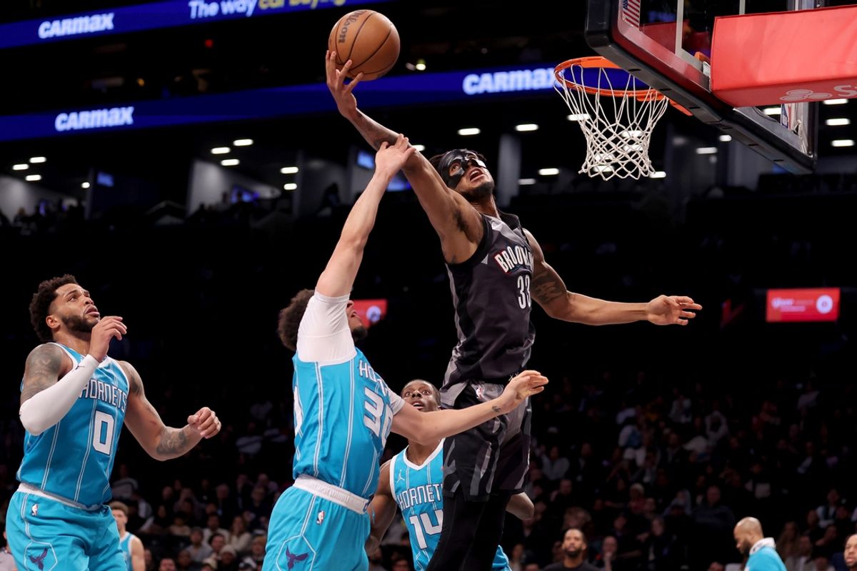 Feb 10, 2025; Brooklyn, New York, USA; Brooklyn Nets center Nic Claxton (33) grabs a rebound against Charlotte Hornets guard Seth Curry (30) and forwards Miles Bridges (0) and Moussa Diabate (14) during the third quarter at Barclays Center. Mandatory Credit: Brad Penner-Imagn Images