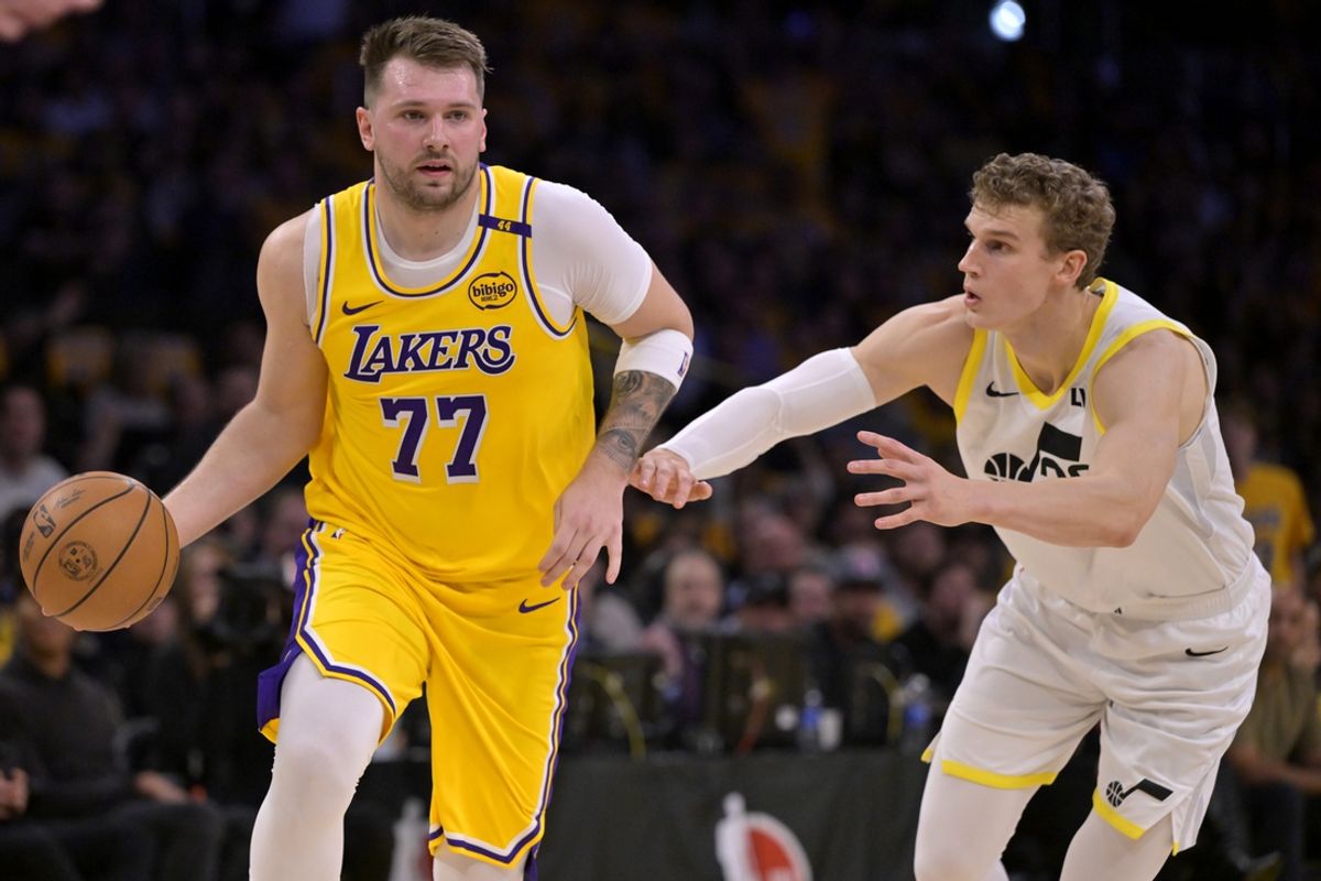 Feb 10, 2025; Los Angeles, California, USA; Los Angeles Lakers guard Luka Doncic (77) is defended by Utah Jazz forward Lauri Markkanen (23) in the first quarter at Crypto.com Arena. Mandatory Credit: Jayne Kamin-Oncea-Imagn Images