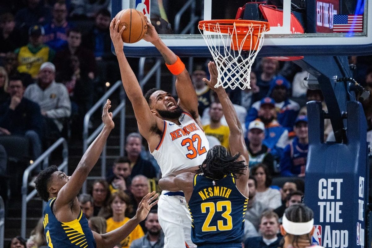 Feb 11, 2025; Indianapolis, Indiana, USA; New York Knicks center Karl-Anthony Towns (32) shoots the ball while  Indiana Pacers center Thomas Bryant (3) and forward Aaron Nesmith (23) defend in the first half at Gainbridge Fieldhouse. Mandatory Credit: Trevor Ruszkowski-Imagn Images
