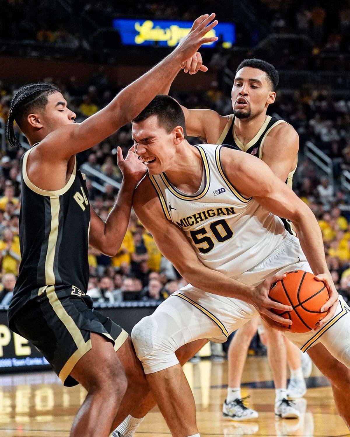 Michigan center Vladislav Goldin (50) dribbles against Purdue guard C.J. Cox (0) and Purdue guard C.J. Cox (0) and forward Trey Kaufman-Renn (4) during the second half at Crisler Center in Ann Arbor on Tuesday, Feb. 11, 2025.