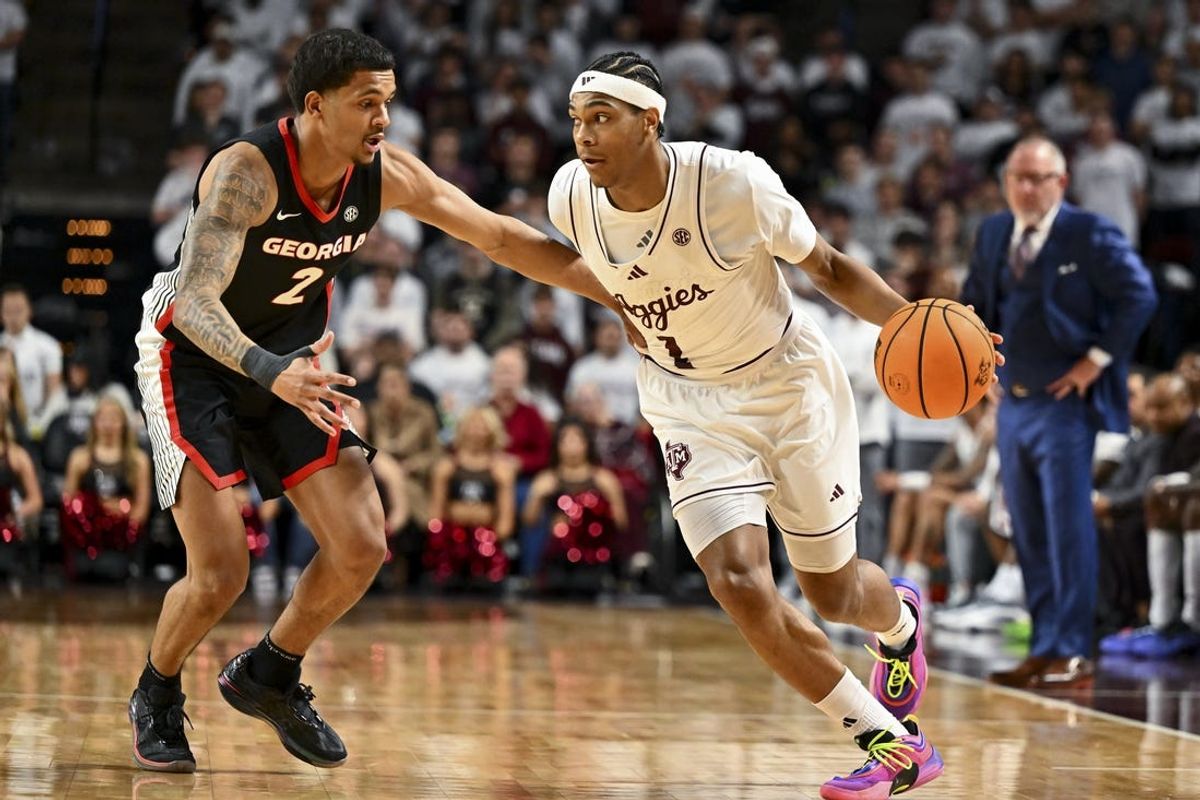 Feb 11, 2025; College Station, Texas, USA; Texas A&M Aggies guard Zhuric Phelps (1) drives as Georgia Bulldogs guard De'Shayne Montgomery (2) defends during the first half at Reed Arena. Mandatory Credit: Maria Lysaker-Imagn Images