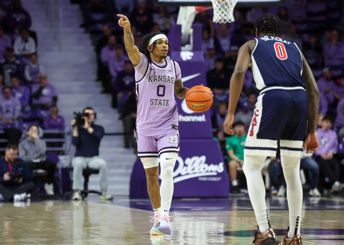 Feb 11, 2025; Manhattan, Kansas, USA; Kansas State Wildcats guard Dug McDaniel (0) brings the ball up court against Arizona Wildcats guard Jaden Bradley (0) during the first half at Bramlage Coliseum. Mandatory Credit: Scott Sewell-Imagn Images