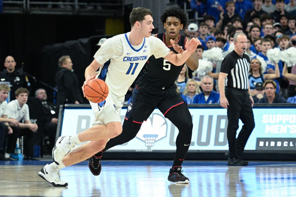 Feb 11, 2025; Omaha, Nebraska, USA;  Creighton Bluejays center Ryan Kalkbrenner (11) dribbles against Connecticut Huskies center Tarris Reed Jr. (5) during the first half at CHI Health Center Omaha. Mandatory Credit: Steven Branscombe-Imagn Images