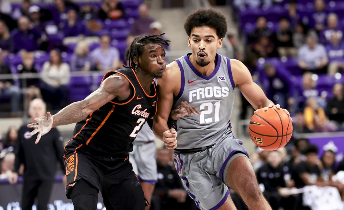 Feb 12, 2025; Fort Worth, Texas, USA;  TCU Horned Frogs guard Noah Reynolds (21) drives to the basket as Oklahoma State Cowboys guard Arturo Dean (2) defends during the first half at Ed and Rae Schollmaier Arena. Mandatory Credit: Kevin Jairaj-Imagn Images
