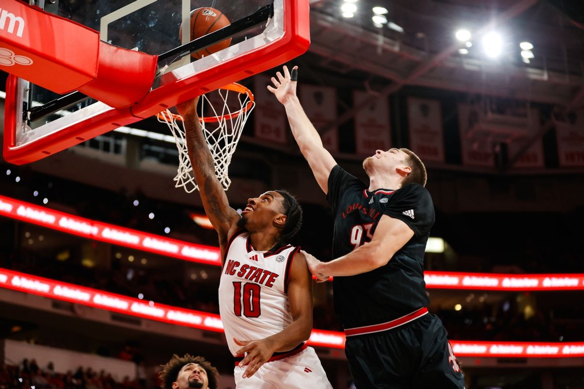Feb 12, 2025; Raleigh, North Carolina, USA; North Carolina State Wolfpack guard Marcus Hill (10) shoots the ball past Louisville Cardinals forward Noah Waterman (93) during the first half of the game at Lenovo Center. Mandatory Credit: Jaylynn Nash-Imagn Images