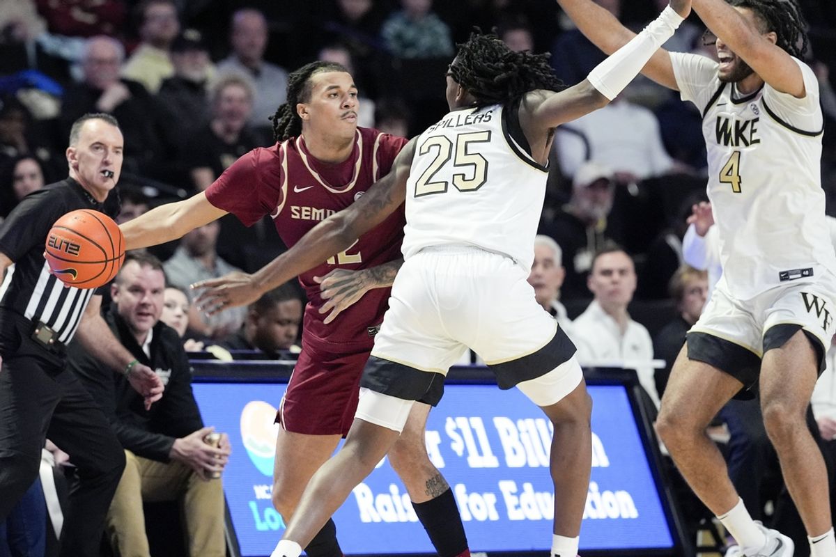 Feb 12, 2025; Winston-Salem, North Carolina, USA; Florida State Seminoles forward Malique Ewin (12) tries to pass around Wake Forest Demon Deacons forward Tre'Von Spillers (25) during the first half at Lawrence Joel Veterans Memorial Coliseum. Mandatory Credit: Jim Dedmon-Imagn Images