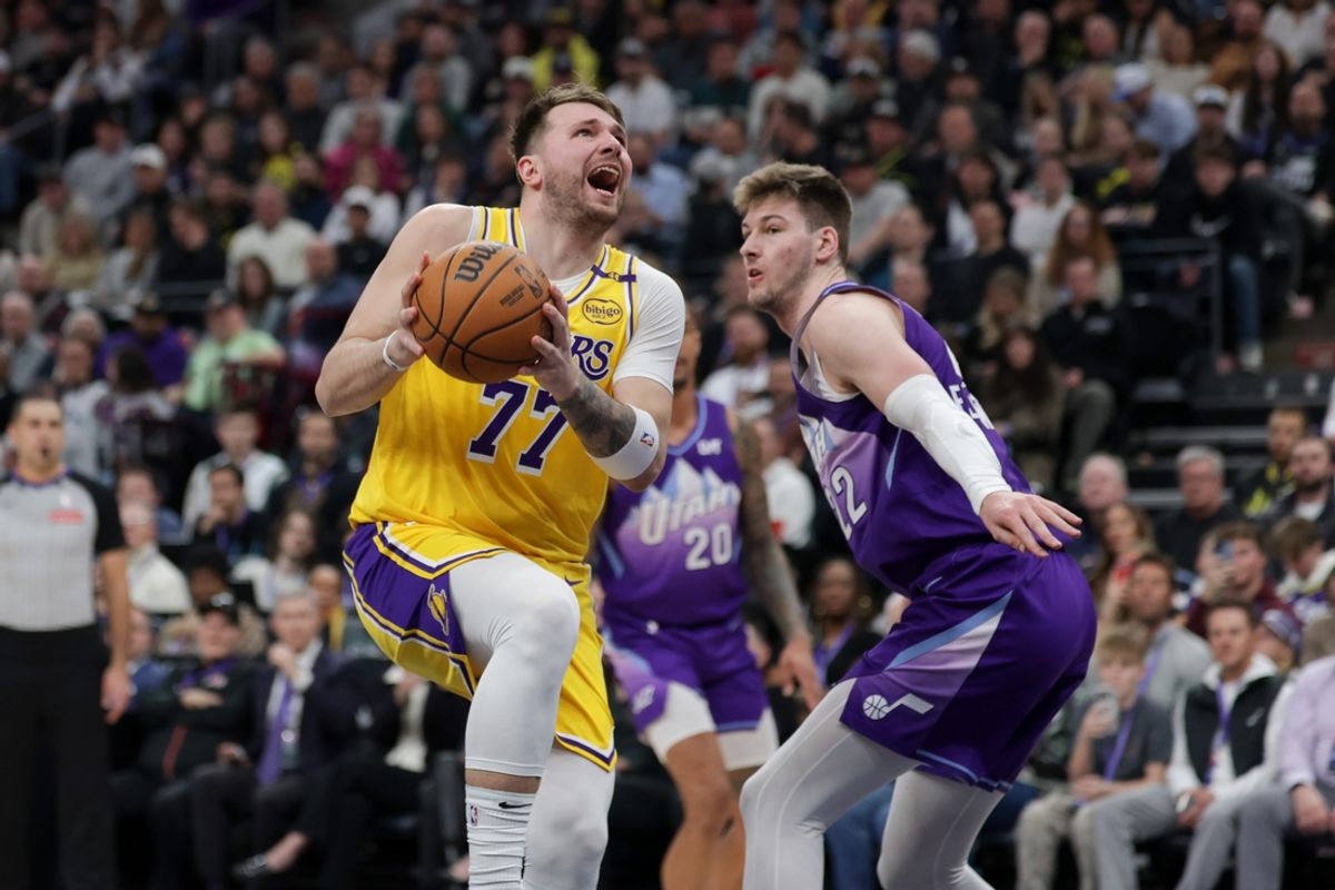 Feb 12, 2025; Salt Lake City, Utah, USA;  Los Angeles Lakers guard Luka Doncic (77) is fouled by Utah Jazz forward Kyle Filipowski (22) during the second quarter at Delta Center. Mandatory Credit: Chris Nicoll-Imagn Images