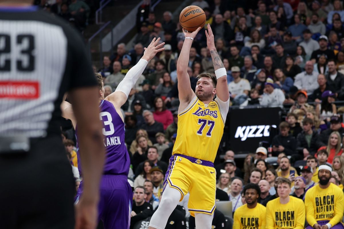 Feb 12, 2025; Salt Lake City, Utah, USA;  Los Angeles Lakers guard Luka Doncic (77) shoots over Utah Jazz forward Lauri Markkanen (23) during the second quarter at Delta Center. Mandatory Credit: Chris Nicoll-Imagn Images