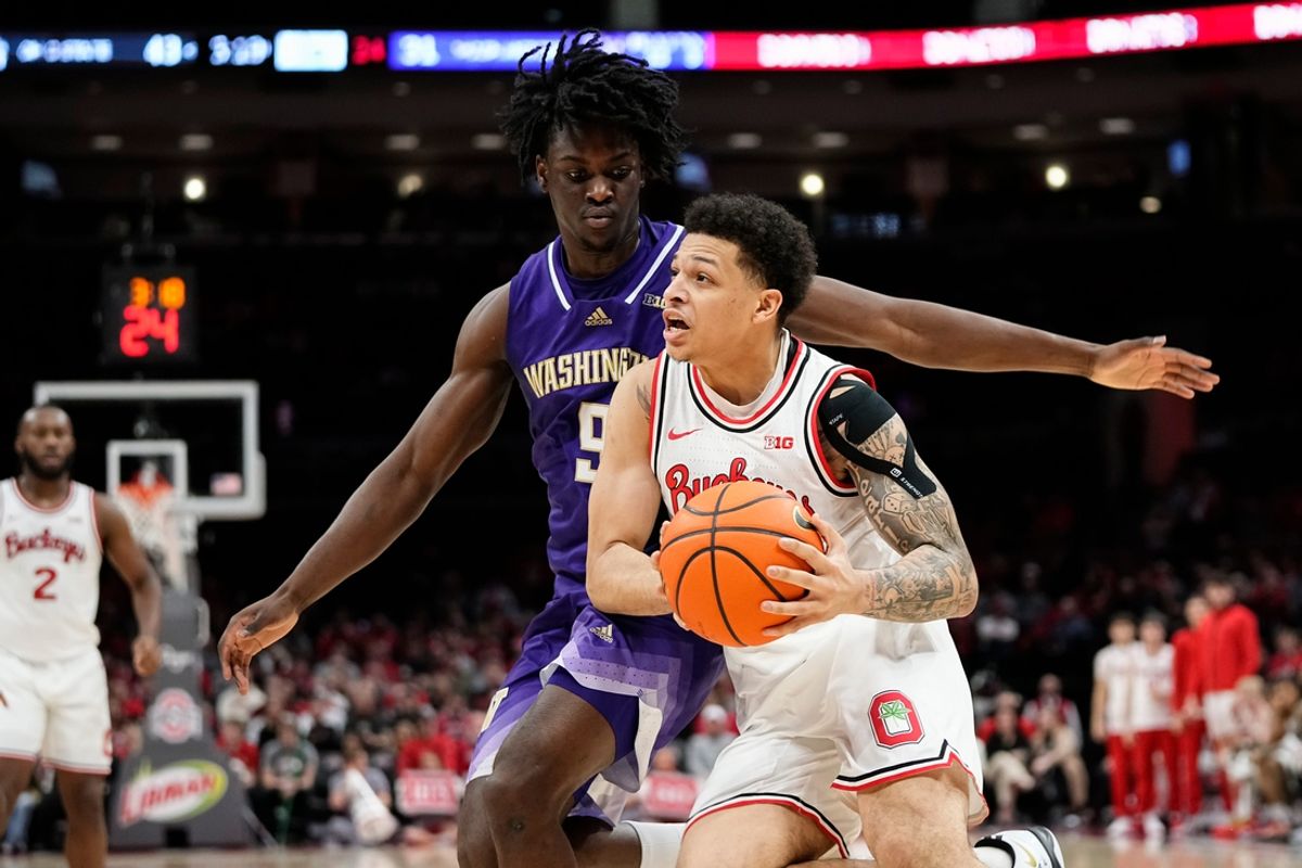 Ohio State Buckeyes guard John Mobley Jr. (0) drives tot the basket past Washington Huskies guard Zoom Diallo (9) during the NCAA men's basketball game at Value City Arena in Columbus on Feb. 13, 2025. Ohio State won 93-69.