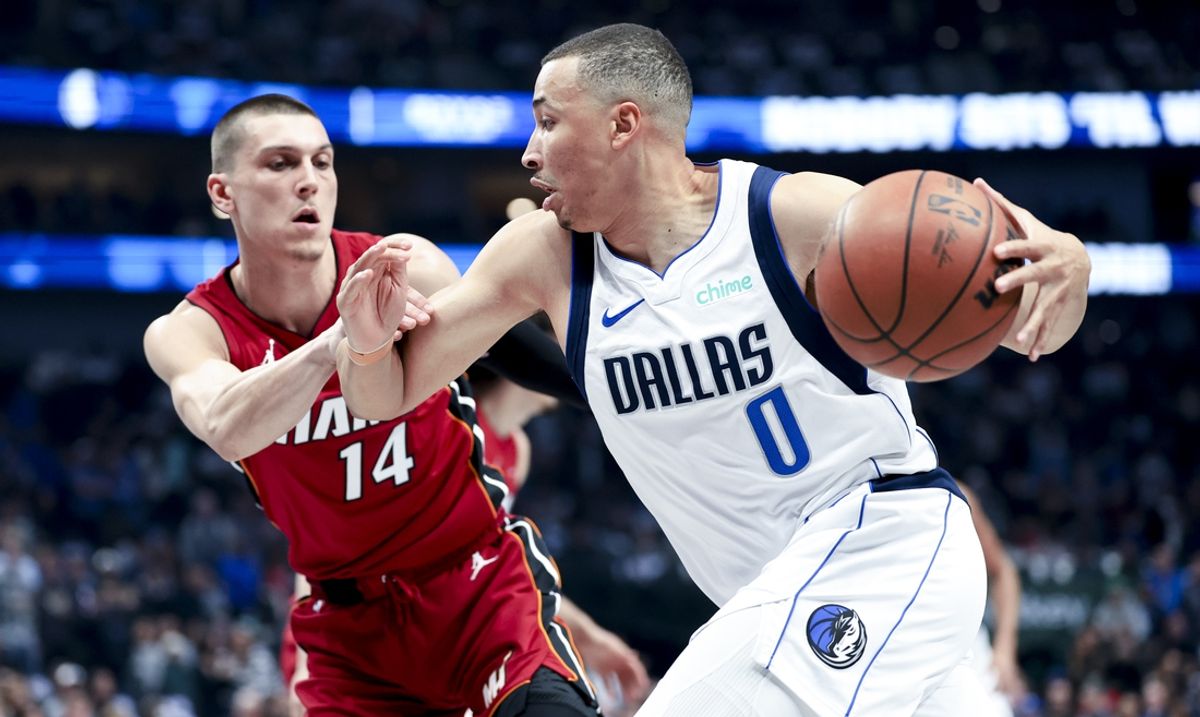 Feb 13, 2025; Dallas, Texas, USA;  Dallas Mavericks guard Dante Exum (0) drives to the basket as Miami Heat guard Tyler Herro (14) defends during the first quarter at American Airlines Center. Mandatory Credit: Kevin Jairaj-Imagn Images