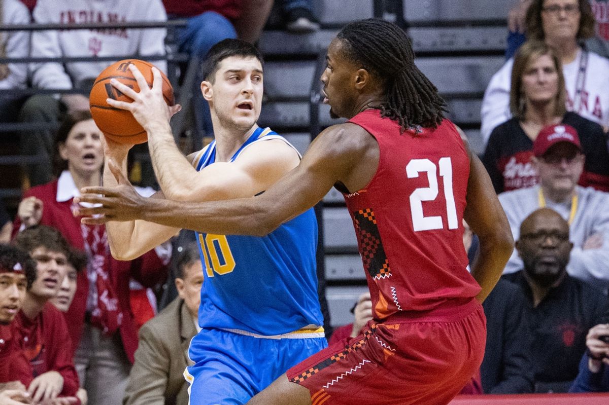 Feb 14, 2025; Bloomington, Indiana, USA; UCLA Bruins guard Lazar Stefanovic (10) holds the ball while Indiana Hoosiers forward Mackenzie Mgbako (21) defends in the first half at Simon Skjodt Assembly Hall. Mandatory Credit: Trevor Ruszkowski-Imagn Images