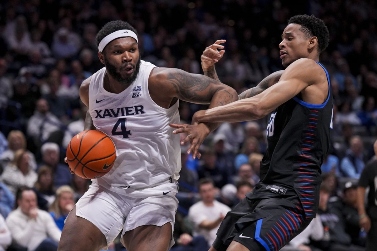 Feb 15, 2025; Cincinnati, Ohio, USA;  Xavier Musketeers forward John Hugley IV (4) drives to the basket against DePaul Blue Demons forward JJ Traynor (20) in the first half at the Cintas Center. Mandatory Credit: Aaron Doster-Imagn Images