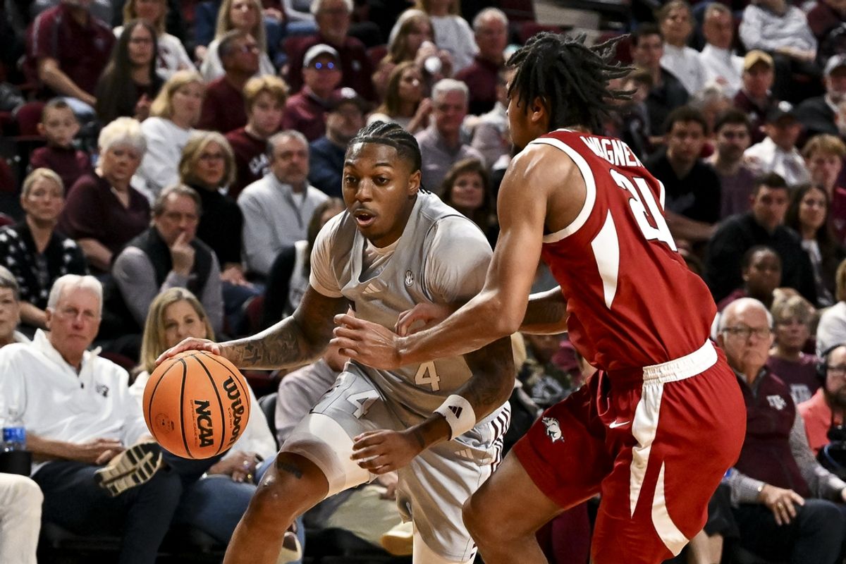 Feb 15, 2025; College Station, Texas, USA; Texas A&M Aggies guard Wade Taylor IV (4) drives as Arkansas Razorbacks guard D.J. Wagner (21) defends during the first half at Reed Arena. Mandatory Credit: Maria Lysaker-Imagn Images