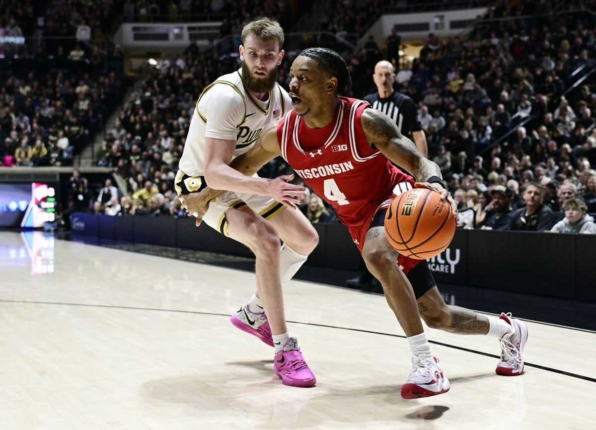 Feb 15, 2025; West Lafayette, Indiana, USA; Wisconsin Badgers guard Kamari McGee (4) drives the ball around Purdue Boilermakers guard Braden Smith (3) during the first half at Mackey Arena. Mandatory Credit: Marc Lebryk-Imagn Images