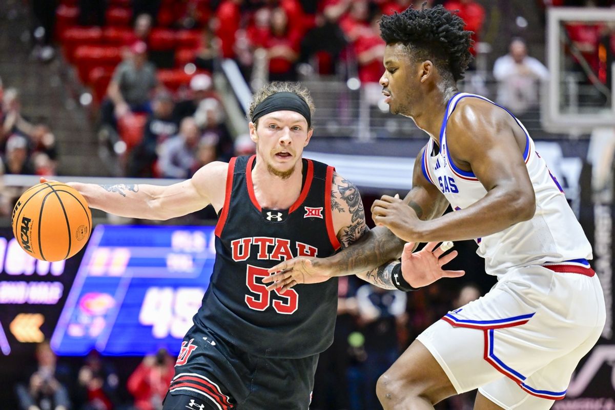 Feb 15, 2025; Salt Lake City, Utah, USA; Utah Utes guard Gabe Madsen (55) drives past Kansas Jayhawks forward KJ Adams (24) during the second half at the Jon M. Huntsman Center. Mandatory Credit: Christopher Creveling-Imagn Images