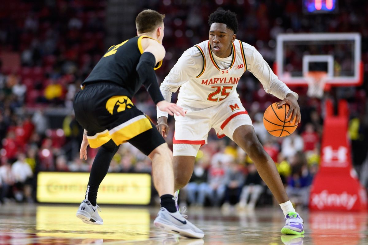 Feb 16, 2025; College Park, Maryland, USA; Maryland Terrapins center Derik Queen (25) handles the ball against Iowa Hawkeyes guard Brock Harding (2) during the second half at Xfinity Center. Mandatory Credit: Reggie Hildred-Imagn Images