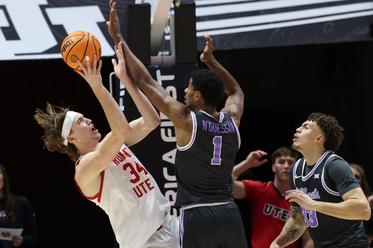 Feb 17, 2025; Salt Lake City, Utah, USA; Utah Utes center Lawson Lovering (34) shoots against Kansas State Wildcats guard David N'Guessan (1) and guard Coleman Hawkins (33) during the first half at Jon M. Huntsman Center. Mandatory Credit: Rob Gray-Imagn Images