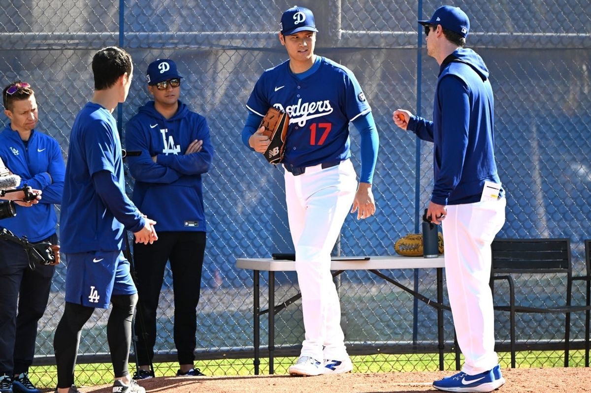 Feb 18, 2025; Glendale, AZ, USA;  Los Angeles Dodgers designated hitter Shohei Ohtani (17) works with Los Angeles Dodgers assistant pitching coach Connor McGuiness (87) during a spring training bullpen session at Camelback Ranch. Mandatory Credit: Jayne Kamin-Oncea-Imagn Images