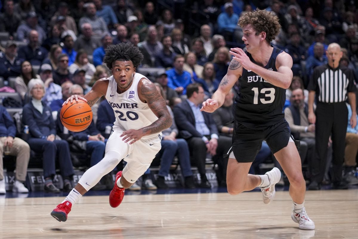 Feb 18, 2025; Cincinnati, Ohio, USA; Xavier Musketeers guard Dayvion McKnight (20) drives to the basket against Butler Bulldogs guard Finley Bizjack (13) in the first half at the Cintas Center. Mandatory Credit: Aaron Doster-Imagn Images