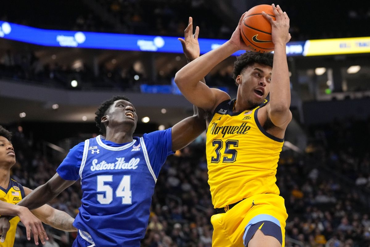 Feb 18, 2025; Milwaukee, Wisconsin, USA;  Marquette Golden Eagles forward Caedin Hamilton (35) grabs a rebound in front of Seton Hall Pirates center Godswill Erheriene (54) during the first half at Fiserv Forum. Mandatory Credit: Jeff Hanisch-Imagn Images