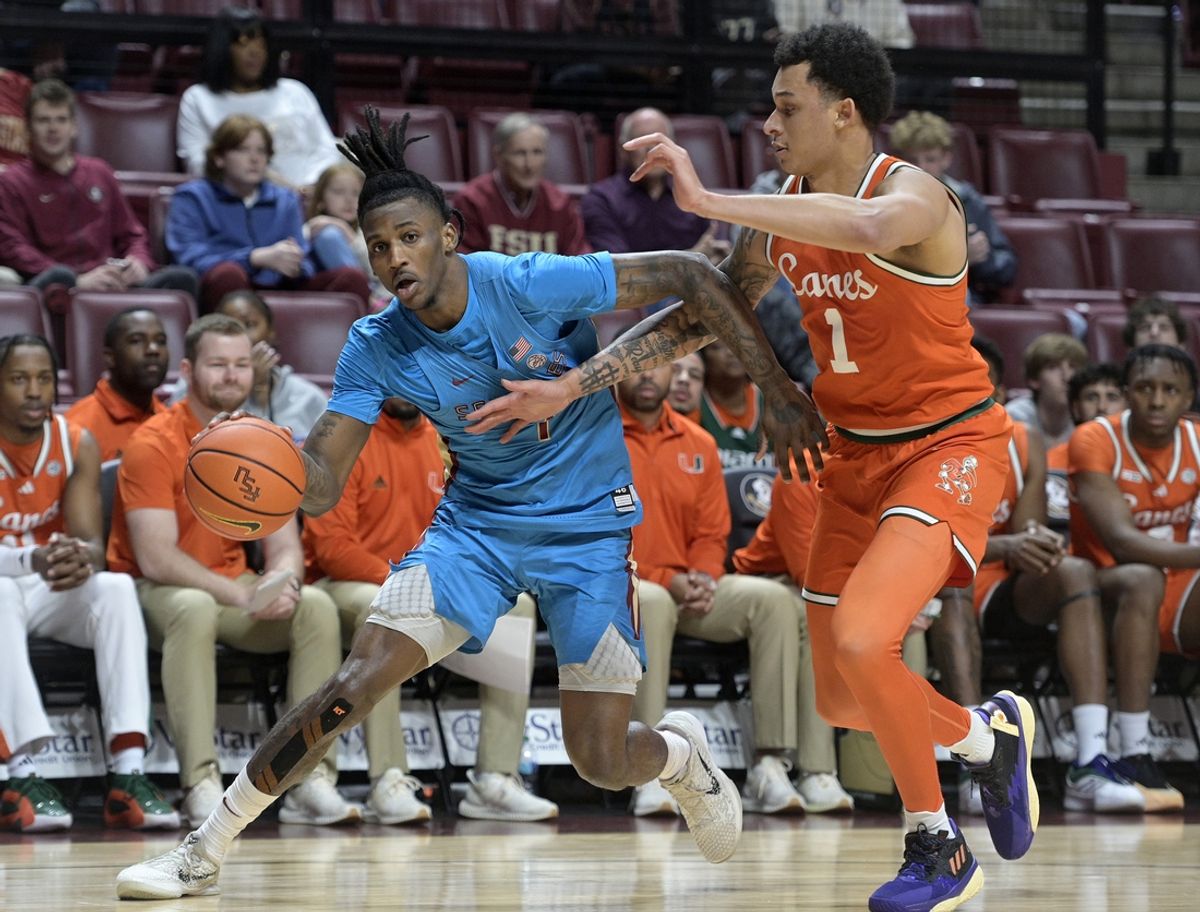Feb 19, 2025; Tallahassee, Florida, USA; Florida State Seminoles forward Jamir Watkins (1) drives to the net past Miami Hurricanes center Lynn Kidd (1) during the first half at Donald L. Tucker Center. Mandatory Credit: Melina Myers-Imagn Images