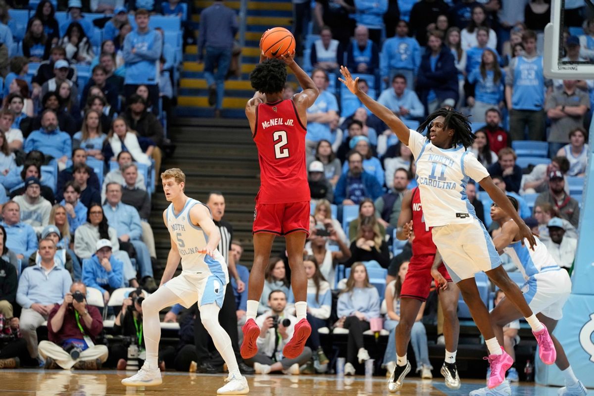 Feb 19, 2025; Chapel Hill, North Carolina, USA; North Carolina State Wolfpack guard Paul McNeil (2) shoots as North Carolina Tar Heels guard Ian Jackson (11) defends in the second half at Dean E. Smith Center. Mandatory Credit: Bob Donnan-Imagn Images