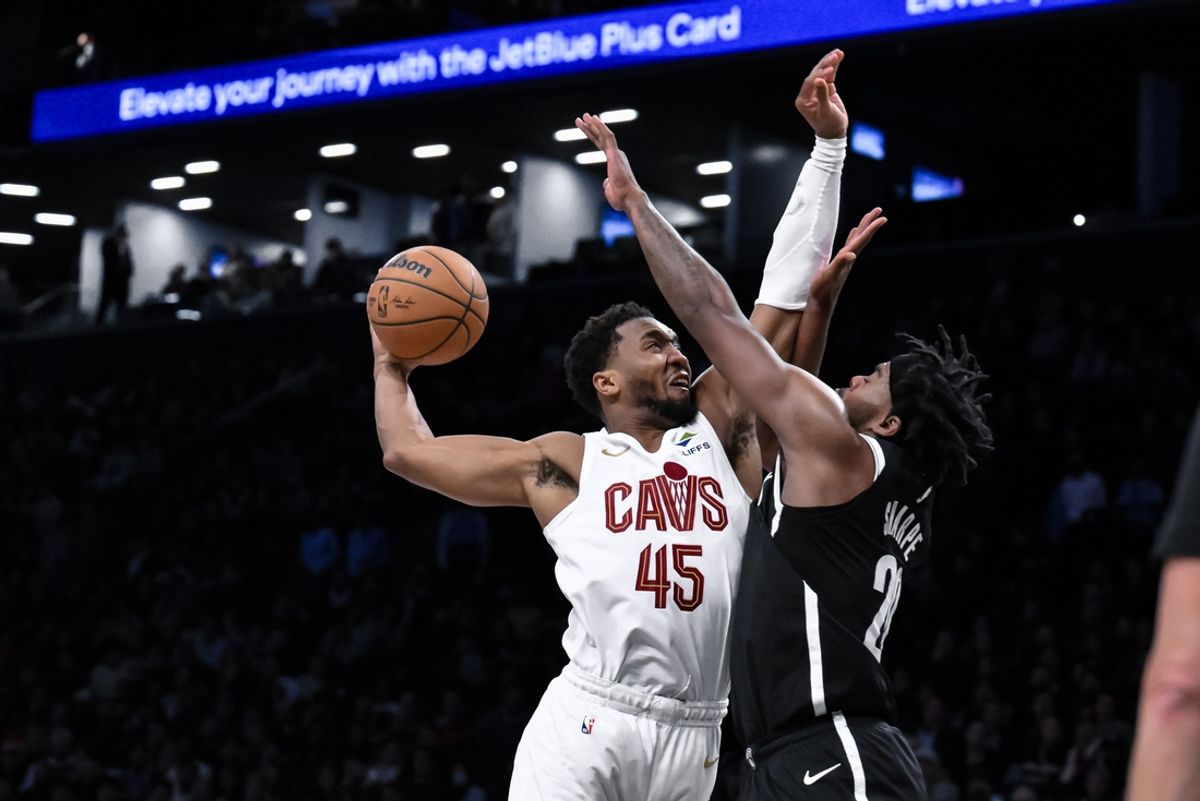 Feb 20, 2025; Brooklyn, New York, USA; Cleveland Cavaliers guard Donovan Mitchell (45) tries to dunk the ball as Brooklyn Nets center Day'Ron Sharpe (20) defends during the second half at Barclays Center. Mandatory Credit: John Jones-Imagn Images