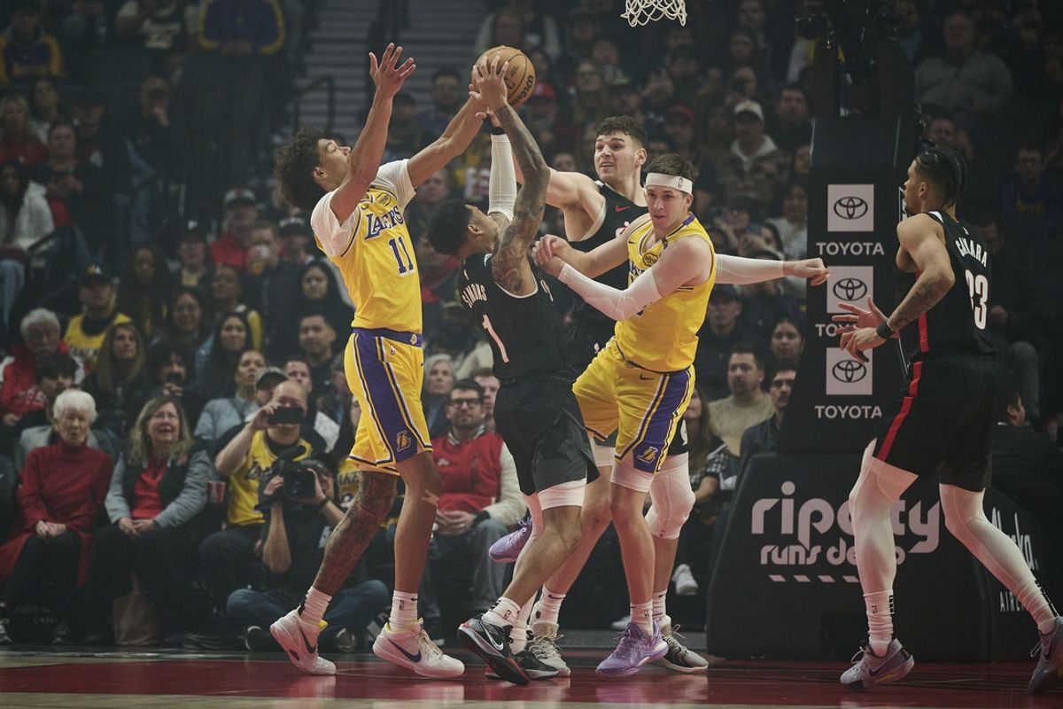 Feb 20, 2025; Portland, Oregon, USA; Portland Trail Blazers guard Anfernee Simons (1) grabs the ball away from Los Angeles Lakers center Jaxson Hayes (11) and guard Austin Reaves (15) during the first half with help from teammate center Donovan Clingan (23) at Moda Center. Mandatory Credit: Troy Wayrynen-Imagn Images
